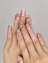 Hand wearing Naillover Silver Charm handmade press on nails with glossy cat eye finish and silver butterfly charms.